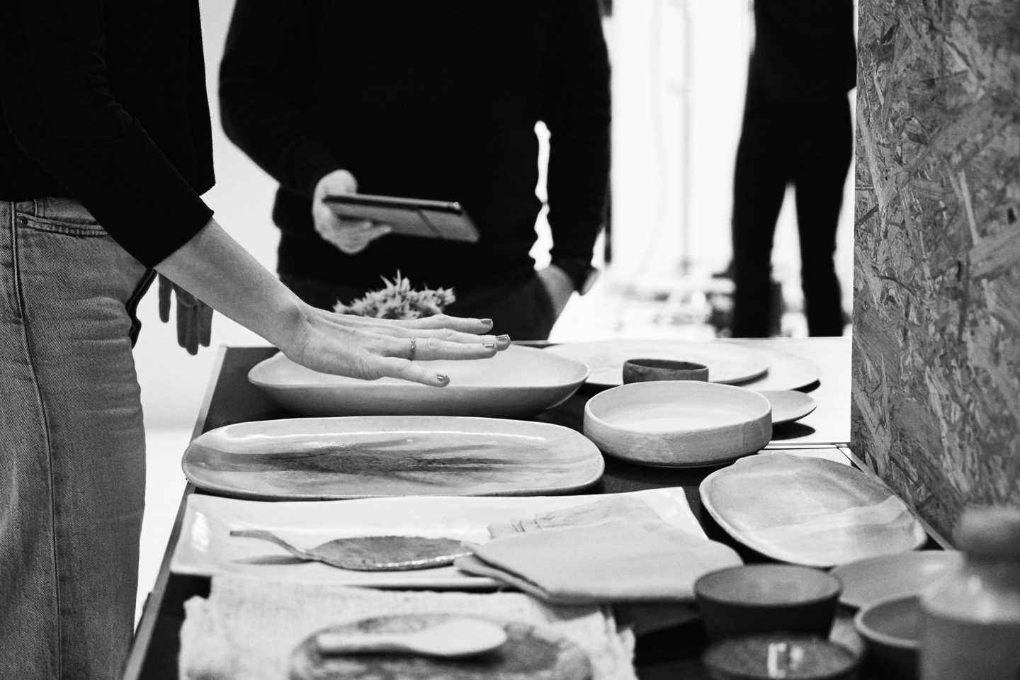 Making-Of Foto in schwarz/weiß welches ein Gespräch der Propstylistin mit dem Foodstylisten zeigt, bei der Auswahl von Requisite | Studio Hackenberg Werbefotograf Kiel
