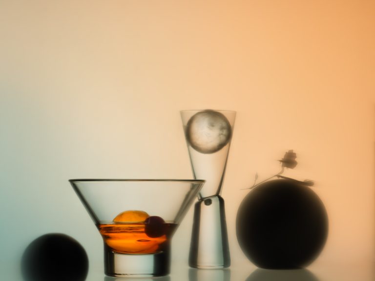 Ein oranges Getränk in einem atmospährischen Setting vor einem Farbverlauf mit Spiegelungen auf dem Boden - Foodfotografie vom Studio hackenberg